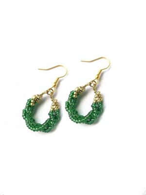 Paire de boucles d’oreilles artisanales en perles vertes et dorées, disposées en forme de petits anneaux torsadés. Boucles d’oreille bohème chic