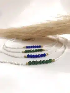 Collier minimaliste en perles blanches avec perles facettées colorées bleues ou vertes et détails dorés, bijou fait main au style délicat et élégant.