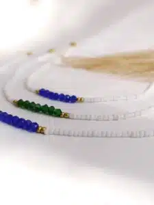 Collier minimaliste en perles blanches avec perles facettées colorées bleues ou vertes et détails dorés, bijou fait main au style délicat et élégant.
