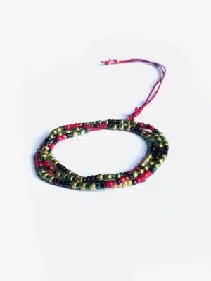 Bracelet artisanal multi-rangs composé de petites perles rouges, vertes, noires et dorées, monté sur un cordon ajustable rouge, présenté sur un fond blanc.
